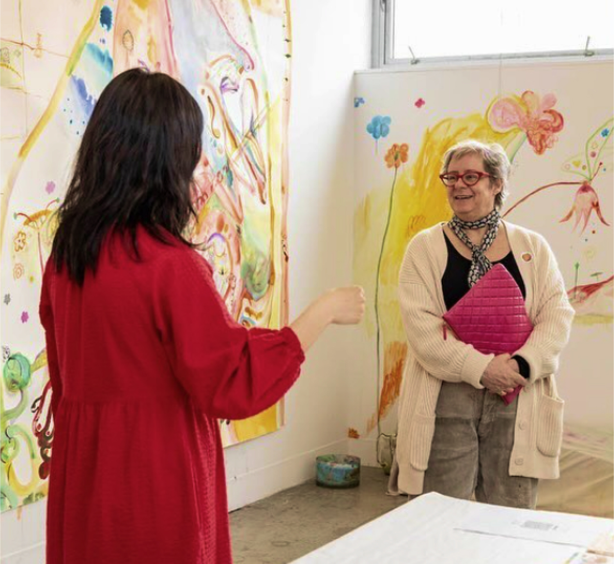 Photo of two people talking and smiling at an exhibit